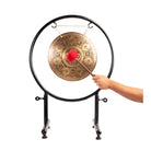 Hand using a mallet to play the Cosmic Mandala Gong.