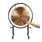 A person striking the Mandala Harmony Gong with a wooden mallet, demonstrating its use during meditation or sound therapy.