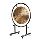 A side view of the Mandala Harmony Gong, featuring intricate mandala patterns on a sturdy black metal stand.